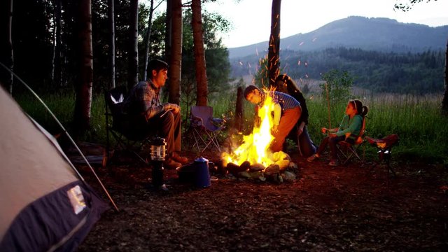 Happy American Caucasian family enjoying camping in forest on vacation outdoor