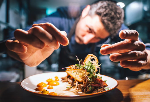 Chef garnishing exquisite plate of food