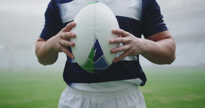 Male rugby player holding rugby ball in the stadium 4k