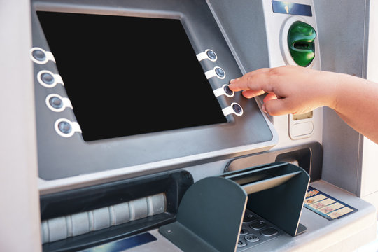 Businesswoman wtihdrawing money from bank atm for transaction