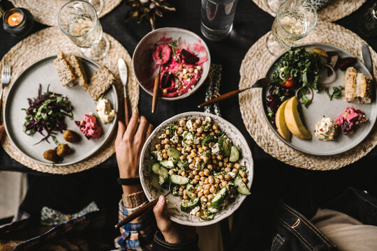 Directly above shot of male and female enjoying food at dining table during social gathering