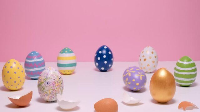 Colorful painted Easter eggs on the pink table. Eggs colored on a pink background. Hello spring and easter concept. 4k video.