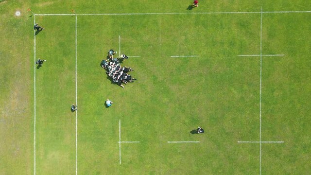 Aerial view Rugby players fight for the ball. Playing rugby on a large green field.