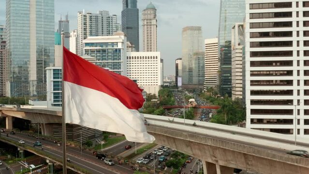 Drone Shot Pulling Away from Indonesian Flag Revealing Downtown Jakarta