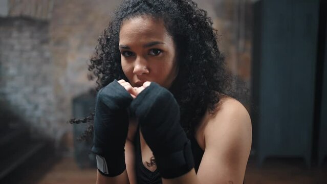 African American woman with kinky hair boxing in camera