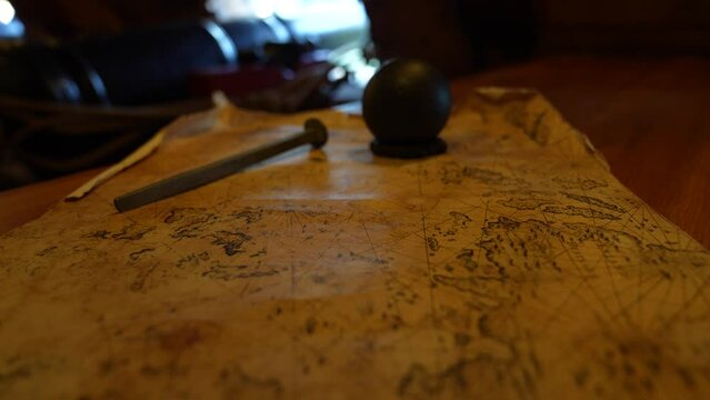 close up of old map map with cannon balls and cannon in the backdrop