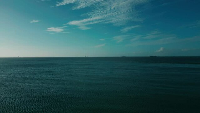 Aerial footage of a blue sea under a cloudy sky