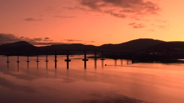 Sunrise drone footage of a boat under the Tasman Bridge in Hobart Tasmania