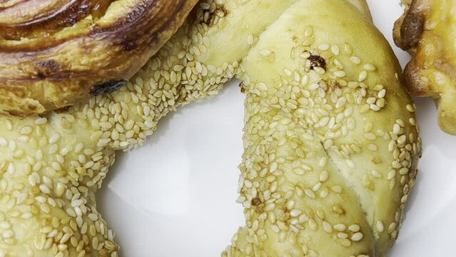 Various types of homemade pastries are spinning on a white plate. Close-up shooting at right angles. Flat ley.