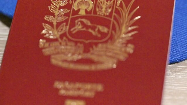 Venezuelan passport and Venezuelan flag with country’s emblem