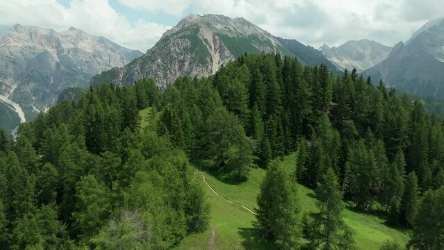 Aerial footage of a drone flying above a forest, a meadow and a mountain hut in the area of Crucs da Rit and Utia da Rit near the village of La Val, South Tyrol, Dolomites, Italy. LuPa Creative.