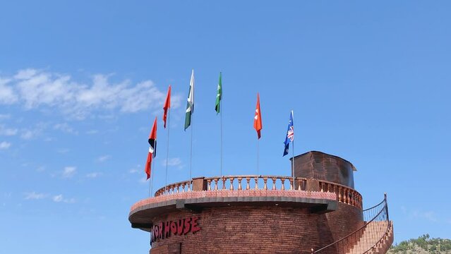 Different flags on the top of a tower in park 