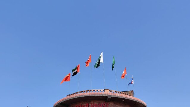 Different flags on top of a tower in park 