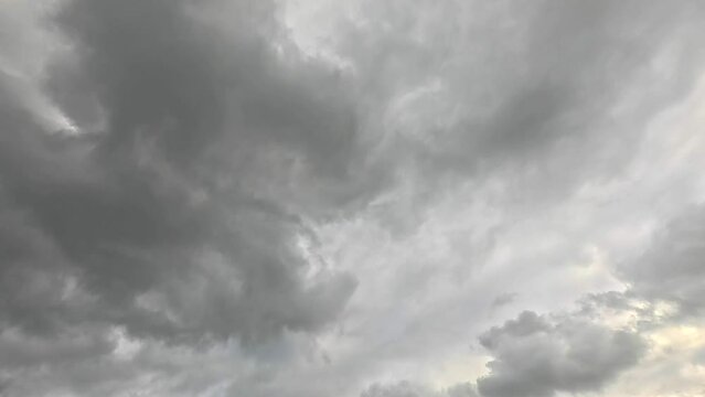 Timelapse of gray stormy clouds floating with sunlight in blue sky