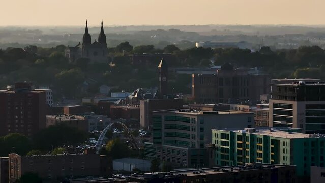 Drone footage of downtown buildings and the Cathedral of Sioux Falls, South Dakota, during sunset.