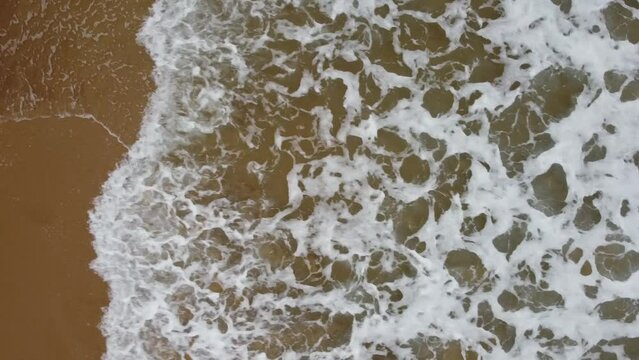 Top-down drone footage of waves at an Australian beach.