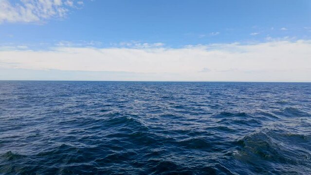 Stock ocean footage in 4k. View of blue ocean and sky with clouds