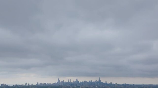 Aerial footage panning down from a cloudy sky to an view of downtown Chicago, Illinois.