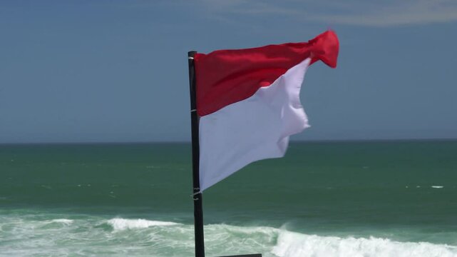 Indonesian country flag flutters in the wind sea breeze, placed by the Drini beach in Yogyakarta.