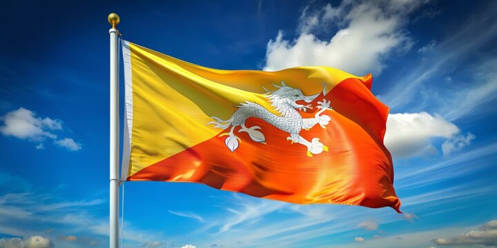 Vibrant yellow and red flag of Bhutan waving in the wind against a clear blue sky, symbolizing the