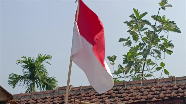 a red and white Indonesian flag fluttering because of the strong wind