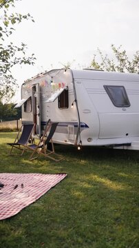 Traveling in caravan, camping and exploring new places. Picnic diner in front of caravan.