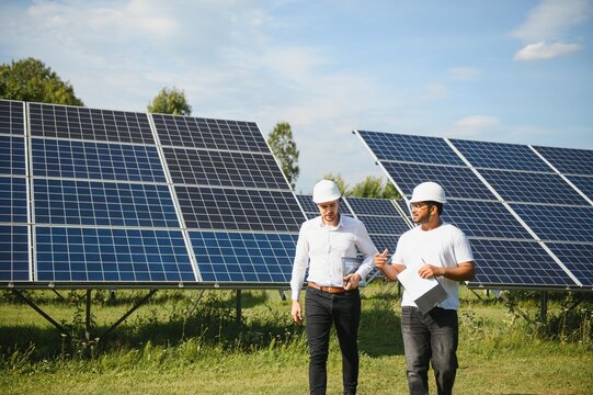 Indian engineer and businessman planing new ecology project. around solar panel