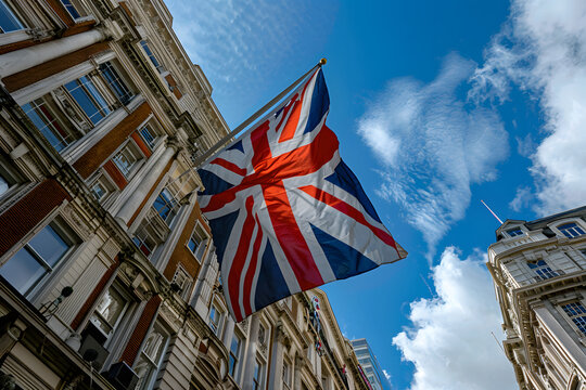 A large British flag is flying in the wind against the backdrop of old European buildings, Generative AI