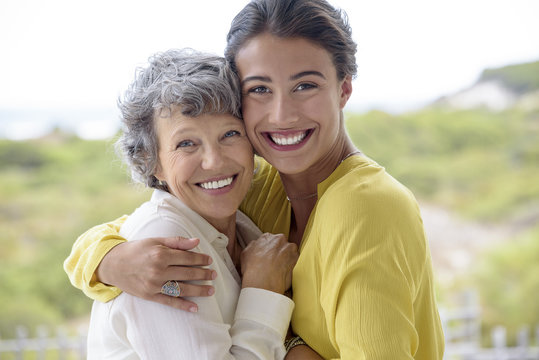 Happy mother hugging her adult daughter outdoors