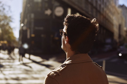 Man in trench coat in city