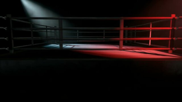 A pan across a empty regular boxing ring surrounded by ropes spotlit in either opposing corner on an isolated dark background