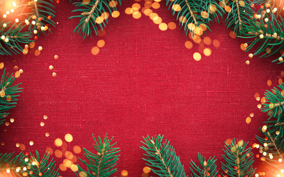 Christmas background with xmas tree and sparkle bokeh lights on red canvas background. Merry christmas card. Winter holiday theme. Happy New Year. Space for text