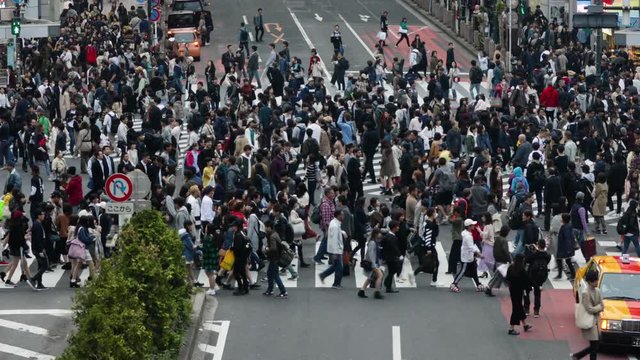 Thousands of people walk across the famous Shibuya Crossing in Tokyo Japan