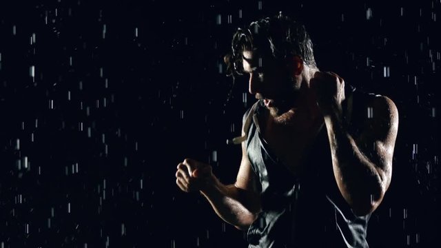 Athletic man shadow boxing in the rain.