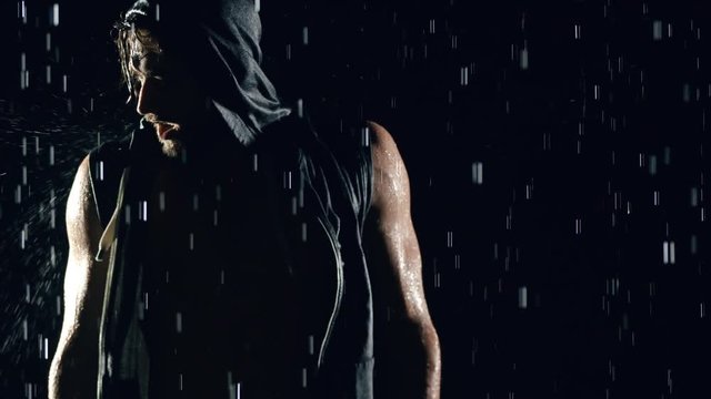 Athletic man shadow boxing in the rain.