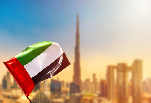 Amazing Dubai skyline cityscape with modern skyscrapers and UAE flag. Downtown of Dubai at sunny day, United Arab Emirates.