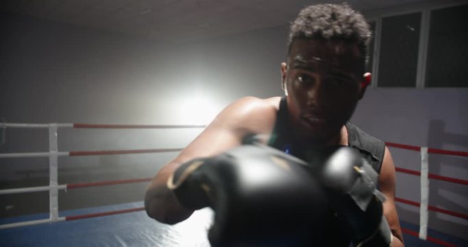 African american sportsman sparring on a boxing ring, punching his opponent at camera - sports, active way of life concept 4k footage