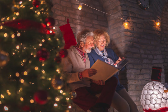 Senior couple looking through old photo album on Christmas Eve