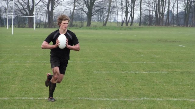 Rugby Match. Players pass the ball to their team on the rugby field. Slow motion