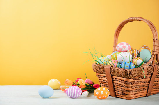 Happy easter, Easter painted eggs in the basket on wooden rustic table for your decoration in holiday. copy space.