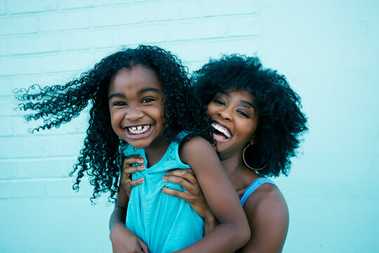 Portrait of Black mother and daughter laughing