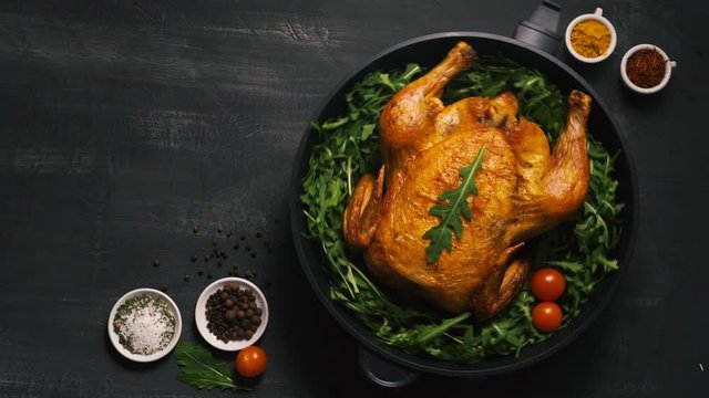 Roasted whole chicken or turkey served in iron pan Placed on black background Top view.