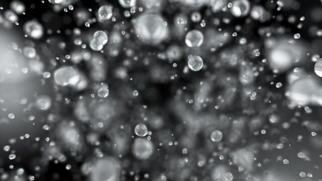 Explosion of water droplets into the camera in slow motion on an isolated black background