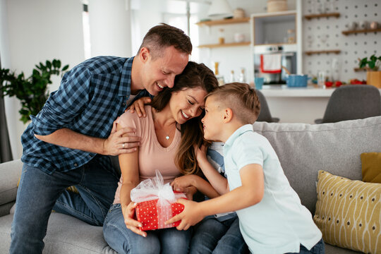 Two young sons are giving their mother a gift. Mother is suprised to receive a present from sons...