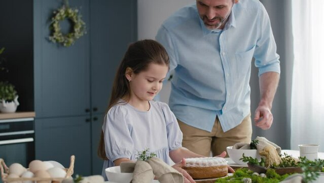 Little girl helping parents in preparing easter table for dinner. Shot with RED helium camera in 8K.