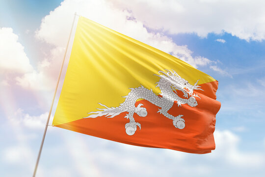 Sunny blue sky and a flagpole with the flag of bhutan