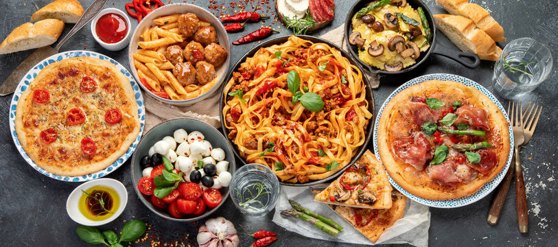 Italian food assortment on dark background.