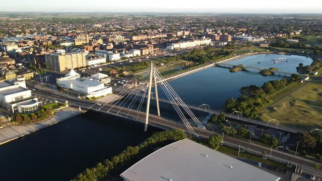 Aerial partial orbital clip of the Millennium Bridge over Southport Marine Lake, Merseyside