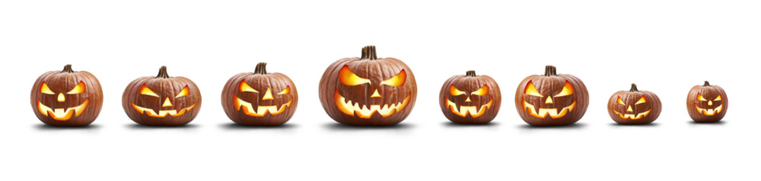 A group of eight lit spooky halloween pumpkins, Jack O Lantern with evil face and eyes isolated against a white background.