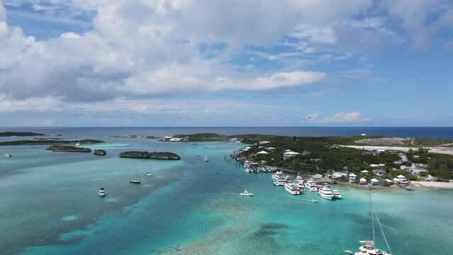 Drone pull out footage of the seascape with islands and boats under the blue sky